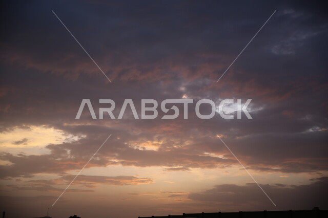 مشهد الغيوم والسحب السوداء في السماء اثناء الغروب، وقت غروب الشمس فوق منطقة ابها، المناظر الطبيعية في مدينة عسير في المملكة العربية السعودية، خلفية الطبيعة