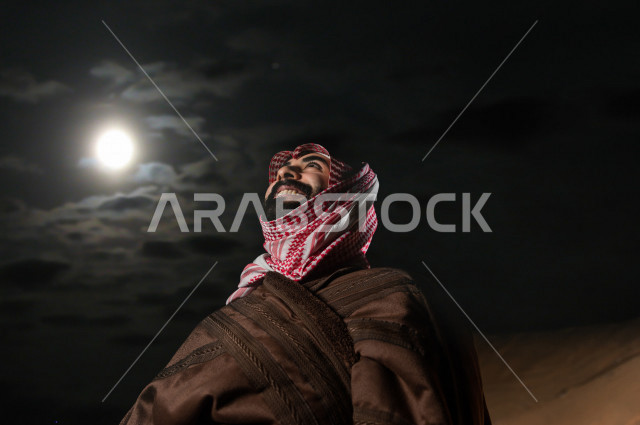 شاب سعودي يتأمل في أجواء شتوية  مسائية  في صحراء المملكة , طلوع البدر في صحاري المملكة العربية السعودية  