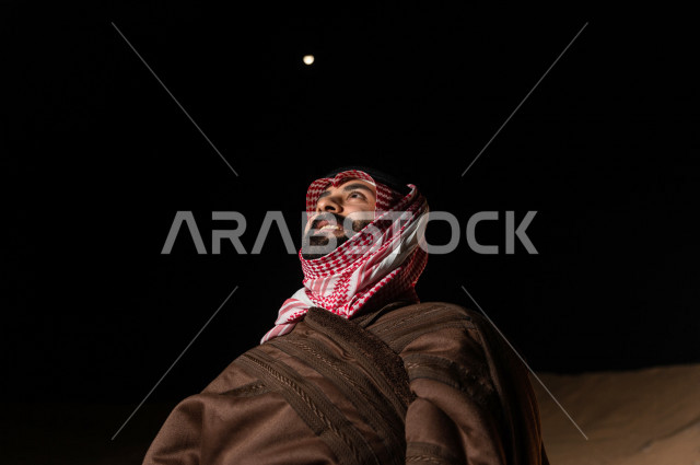 شاب سعودي يتأمل في أجواء شتوية  مسائية  في صحراء المملكة , طلوع البدر في صحاري المملكة العربية السعودية  