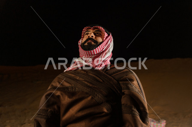 شاب سعودي يتأمل في أجواء شتوية  مسائية  في صحراء المملكة , طلوع البدر في صحاري المملكة العربية السعودية  