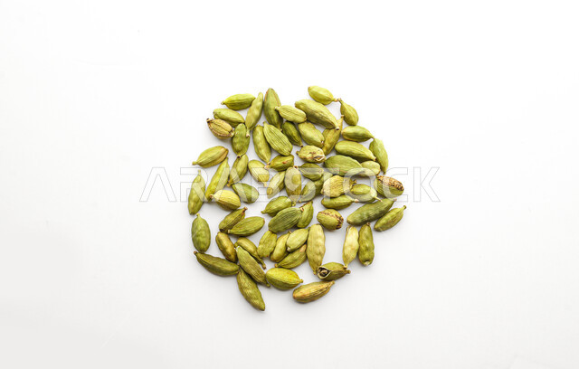 الهال الاخضر ذو الرائحه العطره، حبوب الهيل المجففه، توابل وبهارات لذيذة، محسنات و منكهات طعام، منتج وطني محلي سعودي، خلفية بيضاء