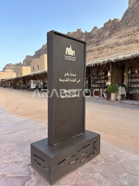 لوحة استقبال بعبارة مرحبا بكم في البلدة القديمة امام المحلات التجارية في السوق التاريخية, الأسواق الشعبية التقليدية في مدينة العلا الاثرية، العراقة والحضارة العربية الاصيلة, المناطق والمعالم والقرى السياحية في المملكة العربية السعودية