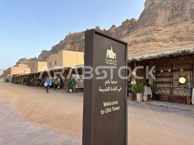 لوحة استقبال بعبارة مرحبا بكم في البلدة القديمة امام المحلات التجارية في السوق التاريخية, الأسواق الشعبية التقليدية في مدينة العلا الاثرية، العراقة والحضارة العربية الاصيلة, المناطق والمعالم والقرى السياحية في المملكة العربية السعودية