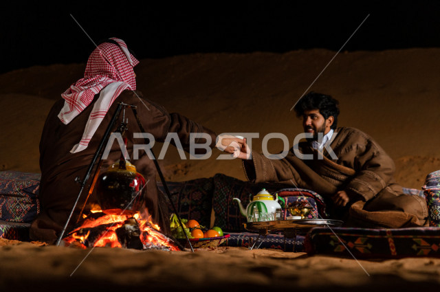 شباب سعوديون  يستمتعان في شرب القهوة العربية في جلسة برية , مغامرة مسائية لإخوان سعوديون  في صحاري السعودية 
