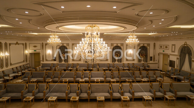 Chairs and tables arranged, a picture from the top of a wedding and event hall, the use of a chandelier for decoration and lighting, wedding halls with interior decorations with distinctive designs.