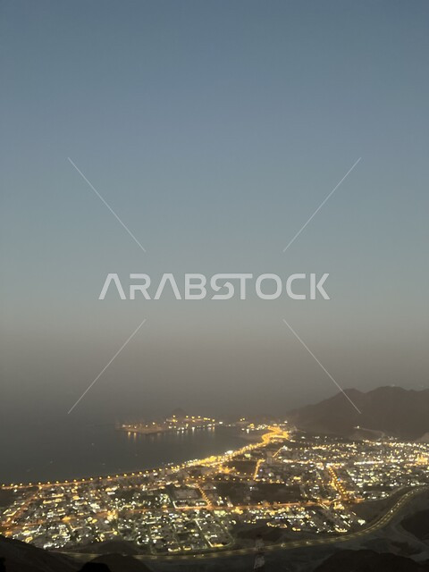 مدن و معالم سياحية في الامارات العربية المتحدة، جذب السائحين من انحاء العالم، صورة جوية للمناظر الطبيعية في مدينة خورفكان في امارة الشارقة ليلا، الاهتمام بزراعة الاشجار والنباتات الخضراء، خلفية الطبيعة