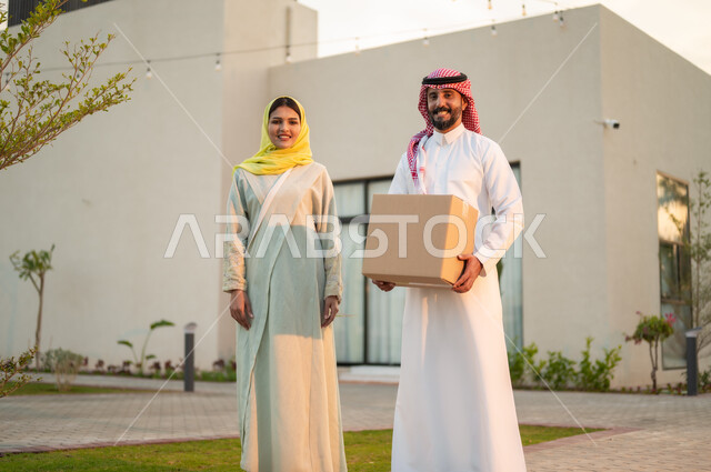 الكمباوند والمجمعات السكنية في السعودية, زوجان عربيان خليجيان سعوديان مبتسمان ينتقلان للعيش في إحدى الأحياء الراقية, الإسكان العائلي في المملكة, فلل وشقق سكنية فاخرة, أجواء أسرية مليئة بالفرح, السرور والبشاشة بامتلاك منزل جديد