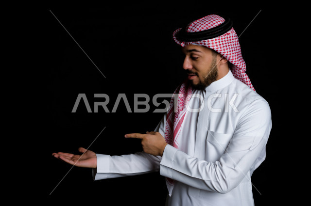 بورتريه لرجل سعودي خليجي سعيد بإيماءات الوجه المختلفة ، تعابير وجه و يدين مختلفة ، خلفية سوداء