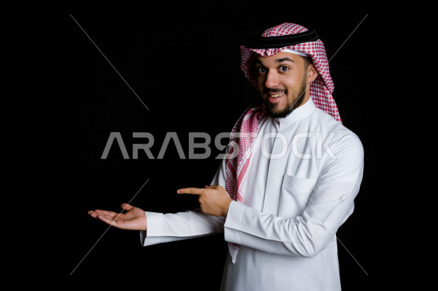 بورتريه لرجل سعودي خليجي سعيد بإيماءات الوجه المختلفة ، تعابير وجه و يدين مختلفة ، خلفية سوداء