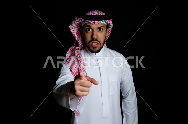 بورتريه لرجل سعودي خليجي غاضب و عابس بإيماءات وجه و يدين مختلفة  ، تعابير وجه و يدين مختلفة ، خلفية سوداء 