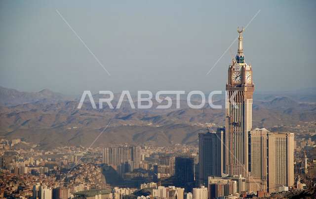 The Royal Clock Tower building overlooking the Holy Mosque in Mecca, the architectural art of towers and skyscrapers in the Kingdom of Saudi Arabia, the distinctive mountainous nature in Mecca, the famous religious landmarks