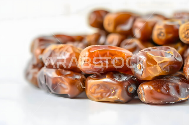 وجبة ذات قيمة غذائية عالية، صورة مقربة لحبات الرطب من نخيل المملكة العربية السعودية، محاصيل ومنتجات زراعية محلية وطنية سعودية، تمر سكري صحي طازج, ضيافة رمضانية لذيذة، خلفية بيضاء