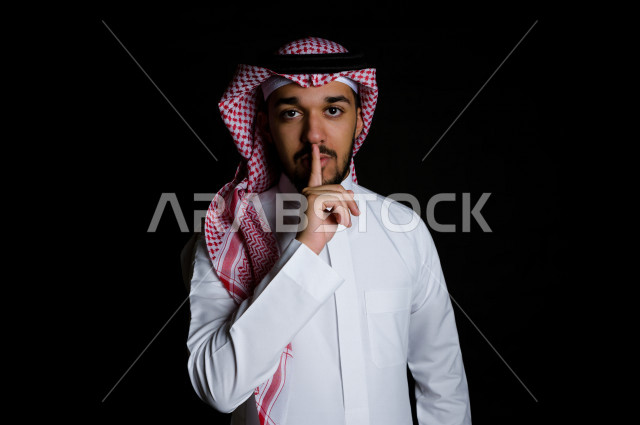 بورتريه لرجل سعودي خليجي غاضب و عابس بإيماءات وجه و يدين مختلفة  ، تعابير وجه و يدين مختلفة ، خلفية سوداء 