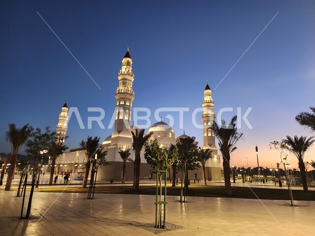 دعوة المسلمين لآداء الصلاة والتقرب إلى الله تعالى، الساحة الخارجية لمسجد قباء في المدينة المنورة وقت الغروب، معالم وأماكن دينية مقدسة في المملكة العربية السعودية، المآذن و القبب المضيئة، الفن الهندسي المعماري والديكورات الاسلامية على الطراز الحديث