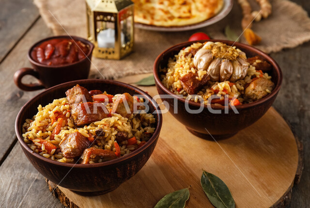 Two plates of delicious kabsa rice with pieces of grilled chicken, popular Saudi Arabian Gulf dishes, the arts of catering in oriental restaurants, traditional foods and dishes, delicious recipes and dishes.