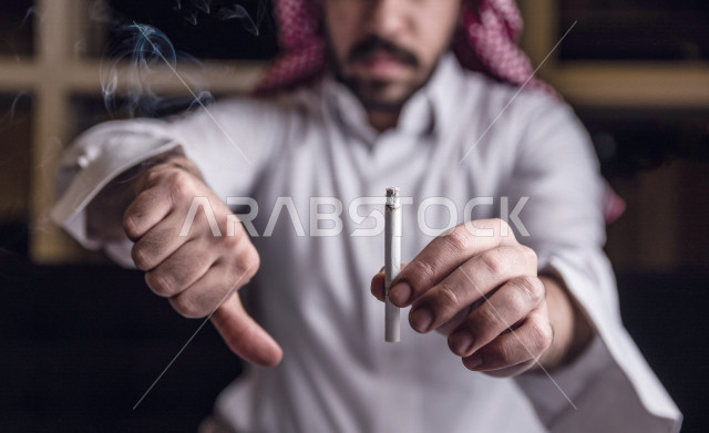 شاب عربي سعودي يحارب عادة التدخين ، ايماءات تدل على التوقف و الحذر من ادمان السجائر، الادمان على التبغ ، ادمان السجائر ، تعاطي مواد ضارة و سامة ، عادات سلوكية ضارة ، لا للتدخين