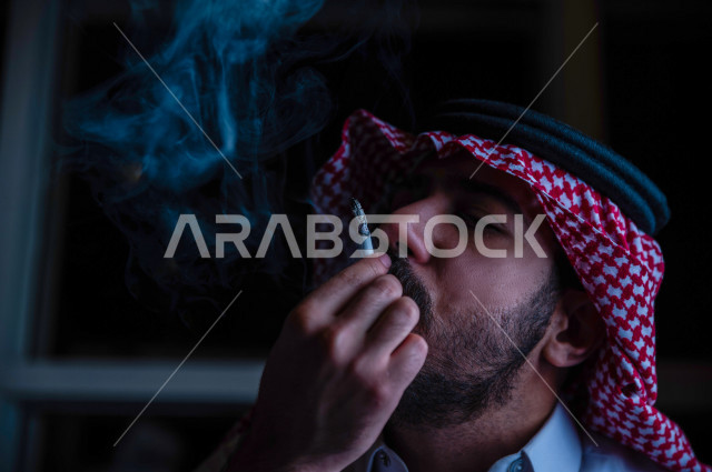A young Saudi Arab who takes a deep breath from a cigarette, tobacco addiction, cigarette addiction, harmful and toxic substance abuse, harmful behavioral habits, no smoking