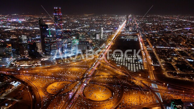 الفن الهندسي المعماري للأبراج وناطحات السحاب، تقاطع طريقي الملك فهد والدائري الشمالي في العاصمة، أفق مدينة الرياض، صورة جوية لحركة سير السيارات في ميدان الرباط في وقت الليل، الطرق والشوارع المشهورة في المملكة العربية السعودية.