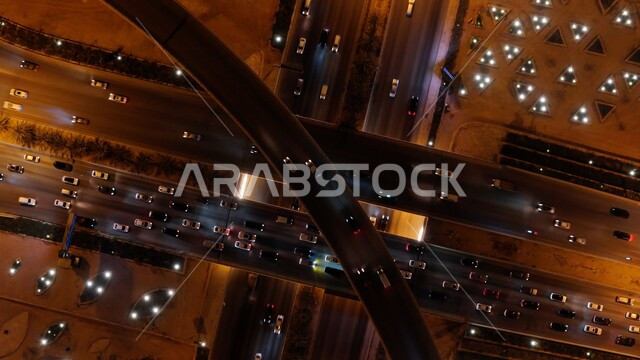 تقاطع طريقي الملك فهد والدائري الشمالي في مدينة الرياض، صورة جوية من الاعلى لحركة سير السيارات في ميدان الرباط في وقت الليل، الفن الهندسي للطرق والشوارع في المملكة العربية السعودية.