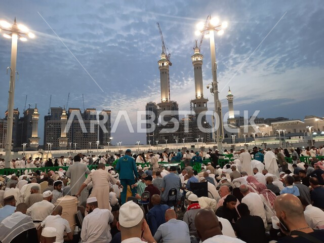 الفن الهندسي المعماري لبناء الأبراج والفنادق المحيطة بالمسجد, أداء العبادات والتقرب الى الله, معالم اسلامية مقدسة, الساحة الخارجية للحرم المكي في مكة المكرمة, الحجاج والمعتمرين في الفناء الخارجي لبيت الله الحرام بانتظار اذان المغرب للإفطار