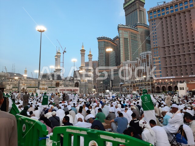 الساحة الخارجية للحرم المكي في مكة المكرمة, الفنادق والأبراج الفاخرة المحيطة بالمسجد، التجمع الاسلامي من كل انحاء العالم لأداء العبادات والتقرب الى الله وانتظار آذان المغرب للافطار, معالم اسلامية مقدسة, الحجاج والمعتمرين في الفناء الخارجي لبيت الله الحرام