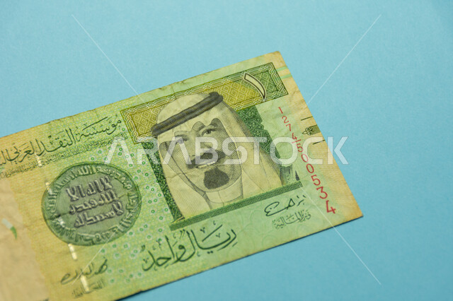 العملات والنقود الورقية المتداولة, صورة خادم الحرمين الشريفين الملك عبد الله بن عبد العزيز آل سعود على العملة الرسمية للمملكة، ورقة نقدية من فئة واحد ريال سعودي من الإصدار الخامس، التمويل والاستثمار المالي, خلفية زرقاء