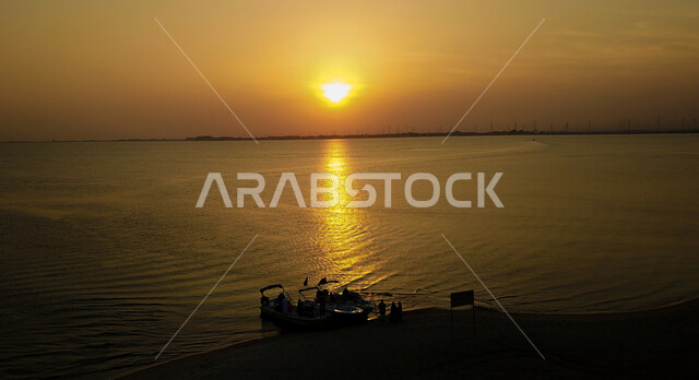 منظر غروب الشمس على الواجهات البحرية في المنطقة الشرقية، معالم سياحيه مشهورة بالمملكة العربية السعودية، مناطق ساحلية ترفيهية، الاستمتاع بالرحلات والنزهات البحرية، صورة جوية للقوارب على شاطئ نصف القمر في الدمام