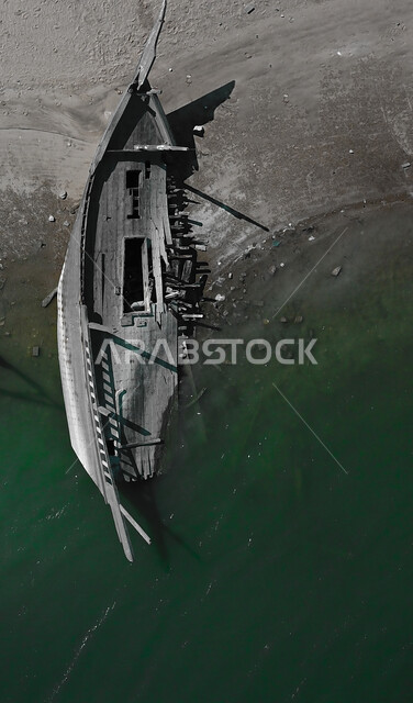 الرمال الذهبية الناعمة على شاطئ نصف القمر في الدمام، الاستمتاع بالرحلات والنزهات البحرية في المنطقة الشرقية، صورة جوية لحطام قارب خشبي في البحر، مناطق ومعالم ساحلية وسياحيه ترفيهية مشهورة