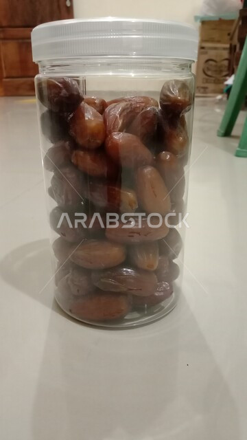 علبة بلاستيكية مليئة بأنواع التمور الصحية الطازجة، وجبة ذات قيمة غذائية عالية، ضيافة رمضانية لذيذة، أسواق شعبية تقليدية لبيع الرطب من نخيل المملكة العربية السعودية، محاصيل ومنتجات زراعية محلية وطنية سعودية
