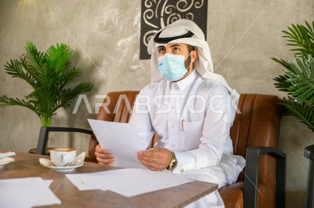 رجلان سعوديان في مقابة عمل يرتديان الكمامة داخل المقهى , بيئة عمل صحية , الحماية من كورونا  