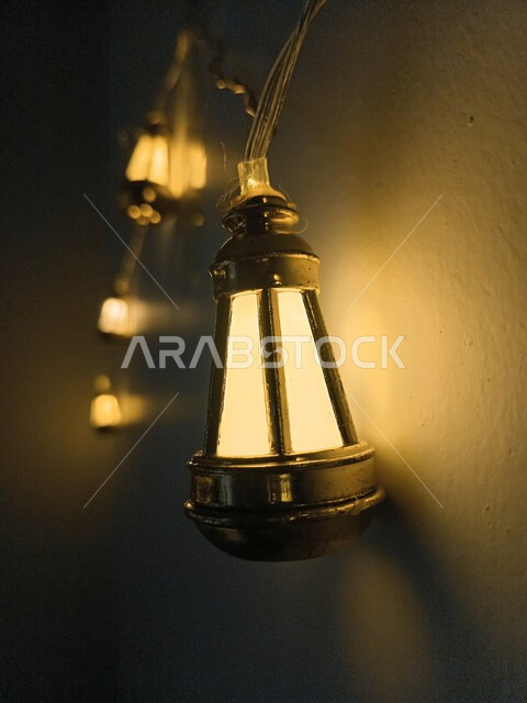 زينة وديكورات المناسبات الدينية، مصباح عربي معدني مضيء معلق على الجدار، فوانيس وتحف تقليدية للاحتفال بقدوم شهر رمضان المبارك، أجواء رمضانية وروحانية إسلامية