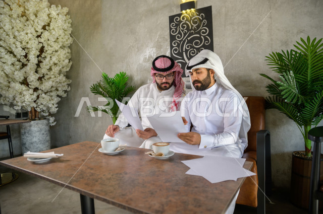 موظفان سعوديان يناقشان مشروع عمل داخل المقهى , اجتماع خليجي في كافيه , تطور مجالات العمل 