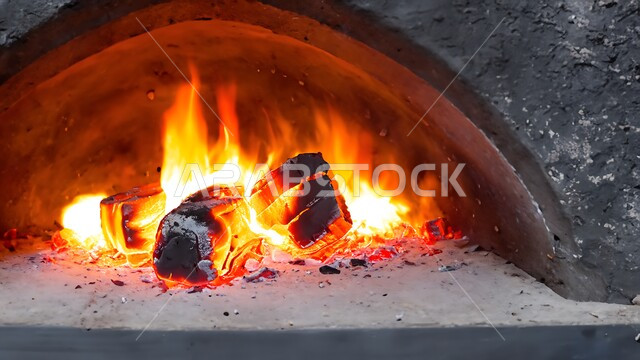 فرن الطين التقليدي القديم, أفران المخبوزات الساخنة في المملكة العربية السعودية, صورة مقربة لموقد الحطب المشتعل