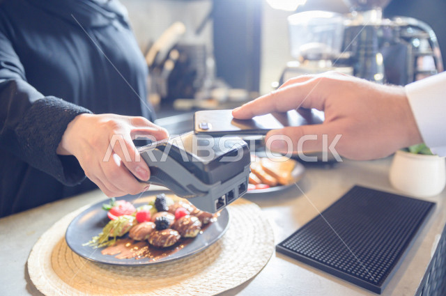 شخص يدفع الحساب بواسطة الهاتف الذكي في المقهى , استخدام نقاط البيع للدفع , سهولة الدفع الآلي 