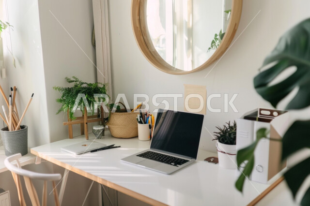  استخدام الاجهزة التقنية الحديثة في المكاتب، مهن ووظائف ادارية عن بعد، ديكورات وتصاميم وأثاث الغرفة باللون الأبيض الراقي، طاولة عمل مجهزة باللوازم المكتبية، العمل على الحاسوب المحمول