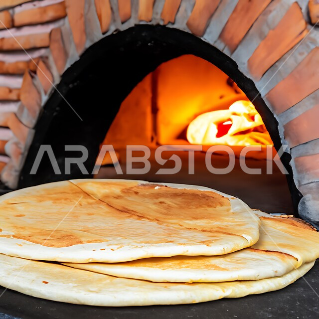 صورة مقربة لأرغفة الخبز العربي التقليدي أمام موقد الحطب، الخبز المفرود في الفرن العربي الشعبي، المخابز والأفران في المملكة العربية السعودية، مخبوزات ساخنة طازجة