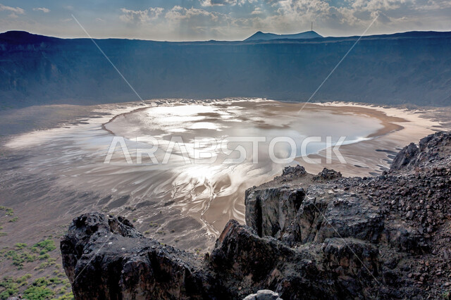 انعكاس الشمس على مياه البحيرة في قاع حفرة الوعبة، الجبال والمرتفعات الصخرية الطبيعية، معالم تاريخية أثرية، الأماكن السياحية في السعودية، (قاع كالديرا) في مقلع طمية في مدينة الطائف في المملكة