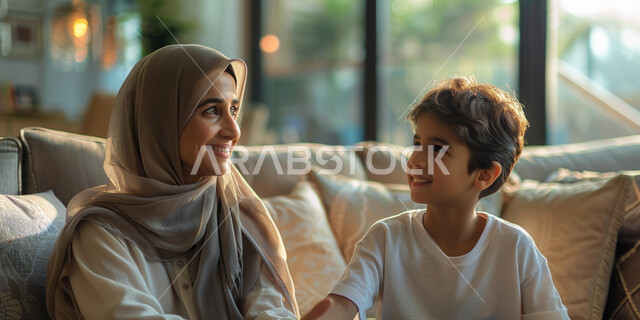منح الابناء وقت مخصص لمشاركة الاحاديث، التسامر وتبادل الاحاديث، صورة مقربة لإمرأة عربية خليجية اماراتية تقضي اوقات ممتعه مع ابنها في المنزل، اجواء عائلية سعيدة