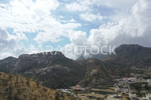 التكوينات والتشكيلات الصخرية، المنحدرات الجبلية القاسية، التضاريس الطبيعية في السعودية، سلسلة جبال السروات في تنومة ضمن منطقة عسير جنوب غرب المملكة، منظر السماء المليئة بالغيوم