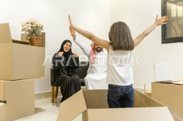 أجواء رائعة لعائلة سعودية سعيدة داخل المنزل الجديد  ، نقل العفش لبيت جديد من خلال العديد من الصناديق متعددة الأحجام ، امتلاك بيت جديد ،ايماءات وجه و يدين تدل على السعادة والانسجام ، الترتيب و التنظيم ، النقل و التوصيل 