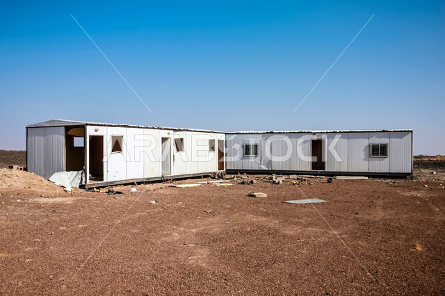 مقطورات بناء مهجورة في الصحراء، الطبيعة الصحراوية والأراضي القاحلة في المملكة، بيوت متنقلة في صحارى السعودية، مشهد السماء الزرقاء الصافية