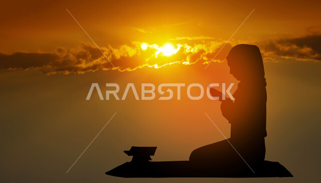 Gestures indicating pleading and supplication, performing the obligatory prayers on time, getting closer to God through diligence in worship and maintaining prayer, a silhouette of a Saudi Gulf Arab woman wearing the hijab and abaya, sitting on the prayer rug, raising her hands and calling upon God, sunset background.