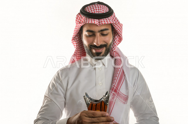 بورتريه لرجل عربي سعودي  يحمل حامل البخور( المبخرة ) ، استخدام خشب العود في المناسبات الاجتماعية و المناسبات الدينية ،  اصالة العادات و التقاليد في المملكة العربية السعودية ، التطيب و التعطر