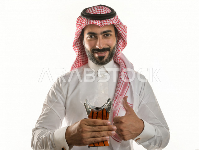 بورتريه لرجل عربي سعودي  يحمل حامل البخور( المبخرة ) ، استخدام خشب العود في المناسبات الاجتماعية و المناسبات الدينية ،  اصالة العادات و التقاليد في المملكة العربية السعودية ، التطيب و التعطر