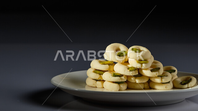 Saudi western desserts with pistachios, dishes of eastern Arab sweets, delicious foods rich in sugars and calories, warm hospitality in the Kingdom of Saudi Arabia, national local products, black background