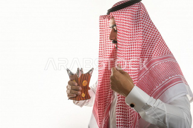 بورتريه لرجل عربي سعودي  يحمل حامل البخور( المبخرة ) ، استخدام خشب العود في المناسبات الاجتماعية و المناسبات الدينية ،  اصالة العادات و التقاليد في المملكة العربية السعودية ، التطيب و التعطر