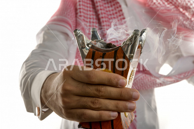 بورتريه لرجل عربي سعودي  يحمل حامل البخور( المبخرة ) ، استخدام خشب العود في المناسبات الاجتماعية و المناسبات الدينية ،  اصالة العادات و التقاليد في المملكة العربية السعودية ، التطيب و التعطر