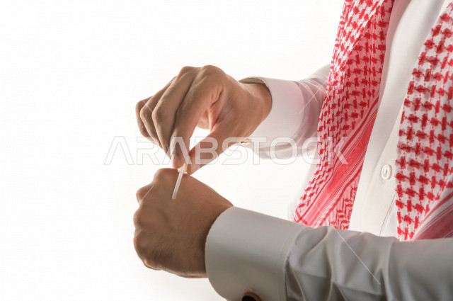Portrait of a Saudi Arab man testing a tola of the luxurious oud aromatic oil on the skin, the Saudi Arabian oud, the use of oud oil in social and religious occasions, the originality of customs and traditions in the Kingdom of Saudi Arabia, perfume and p