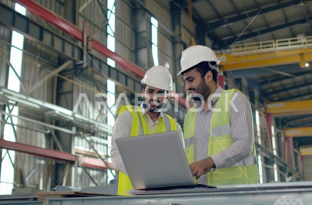الإشراف على المشاريع ومتابعة سيرها، مهندسان عربيان خليجيان سعوديان يرتديان الخوذة وسترة الحماية يتحاوران ويتناقشان في مواضيع العمل، استخدام جهاز الحاسوب المحمول في الأعمال الهندسية، مهن ووظائف سعودية