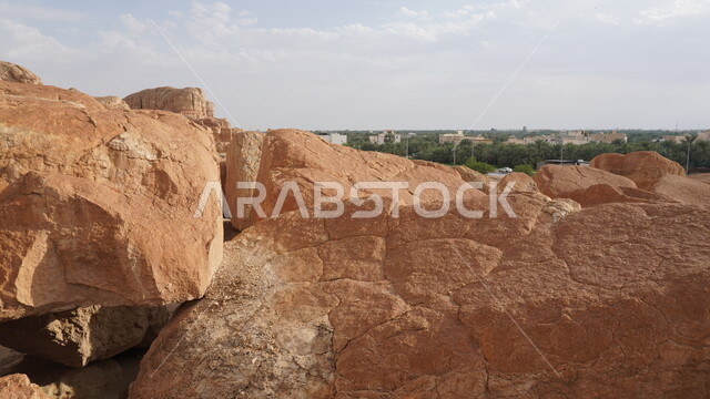 جبل القارة في النهار، منظر الغيوم والسحب البيضاء في السماء، القمم والمرتفعات الجبلية في مدينة الاحساء، المعالم التاريخية الأثرية القديمة في المملكة العربية السعودية، التضاريس الطبيعية والتكوينات والتشكلات الصخرية